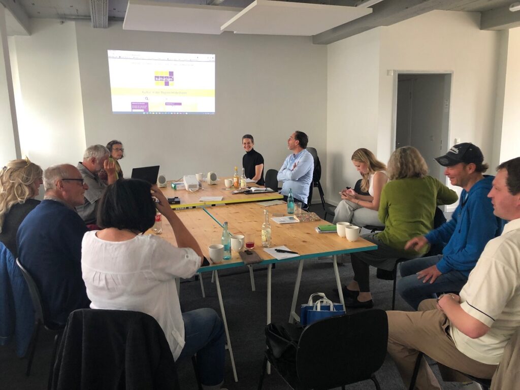 Kulturakteure aus Saale-Orla hören einer Präsentation zu.