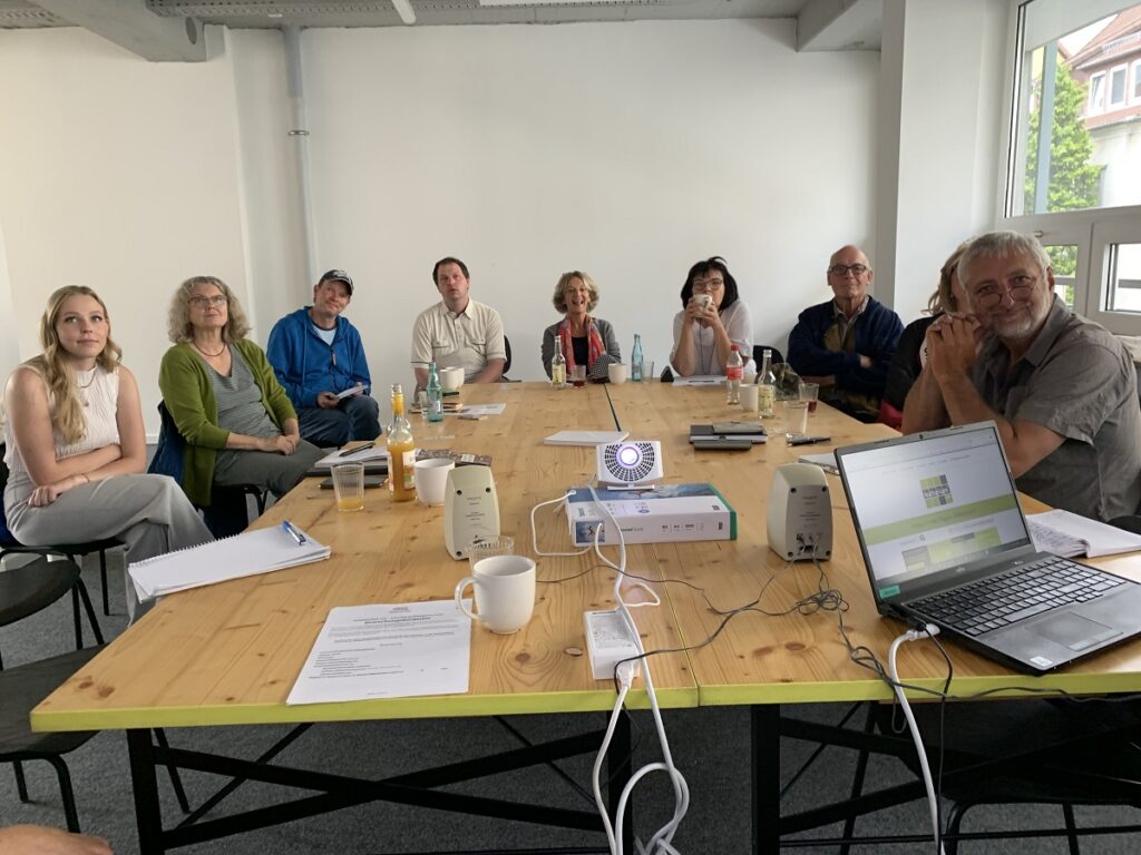 Kulturakteure aus Saale-Orla schauen sich eine Präsentation an.