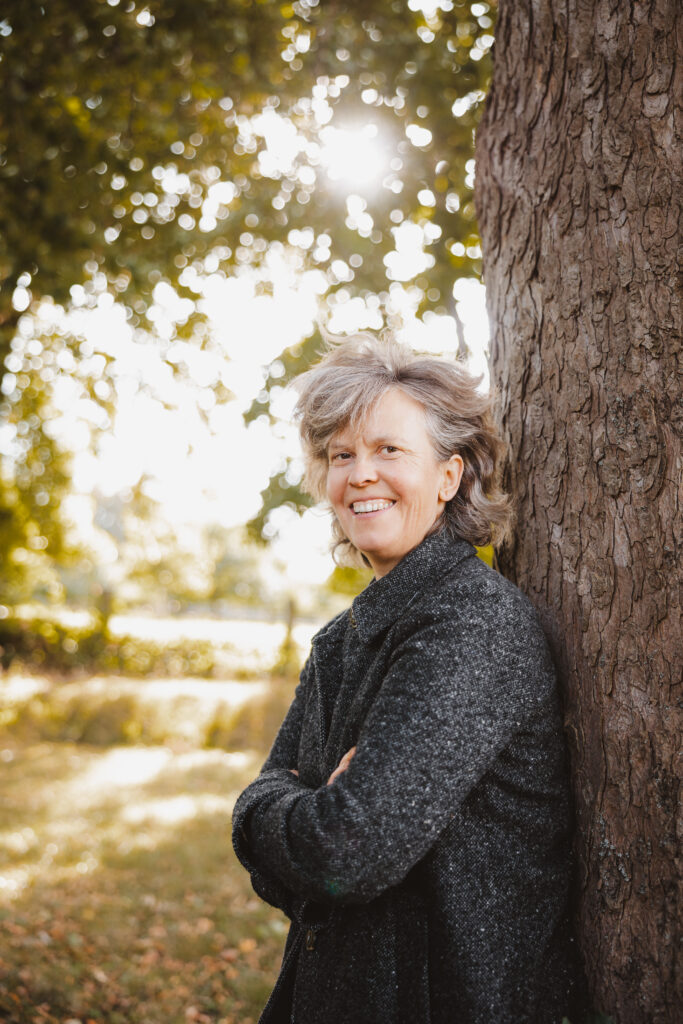 Alexe von Wurmb lehnt an einen Baum auf ihrem Grundstück des Gutshofes Lausnitz.